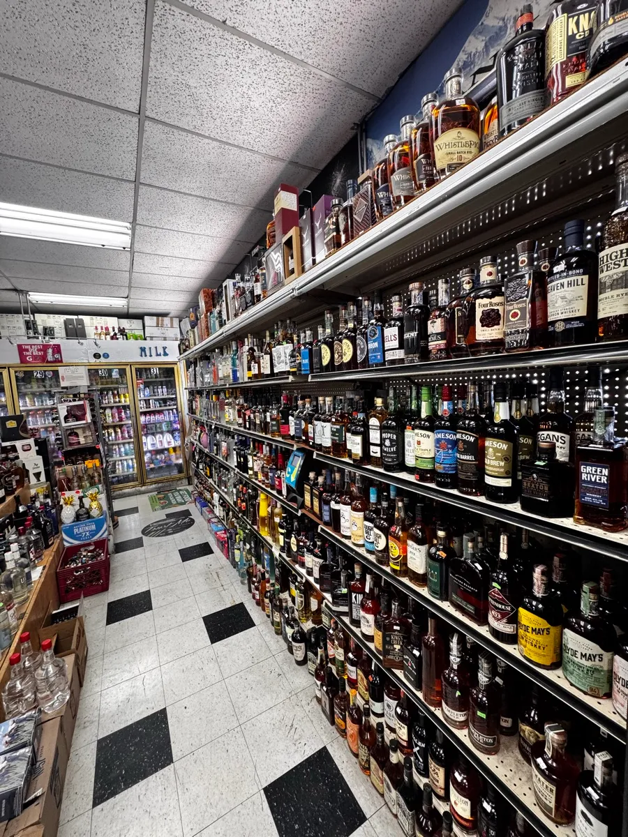 The whiskey wall — shelves of bourbon, scotch and more running the length of the aisle